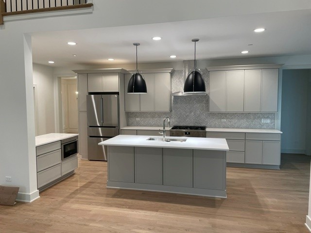 Remodeled kitchen with a light grey island and pendant lighting